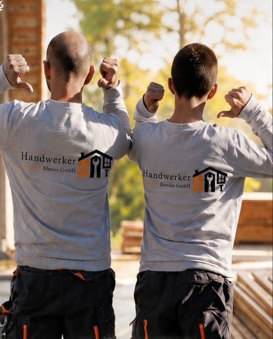 Zwei Mitarbeiter von hinten, auf ihren Pullovern das Logo von Handwerker Blesius